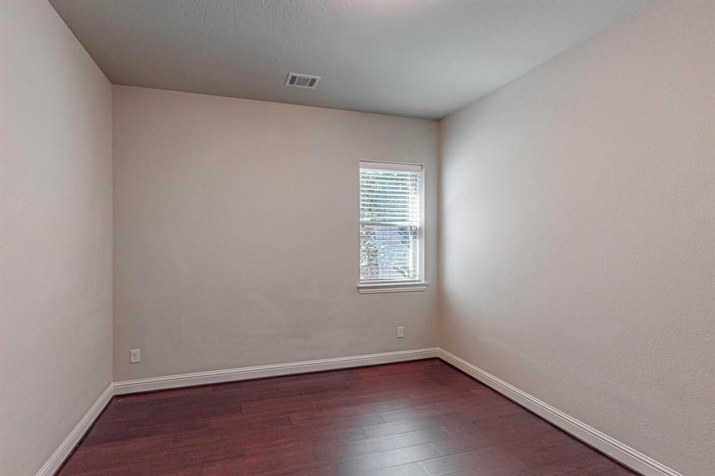 6723 Capistrano Street Irving, TX 75039 - Photo 24 of 40 an empty room with wooden floor and windows