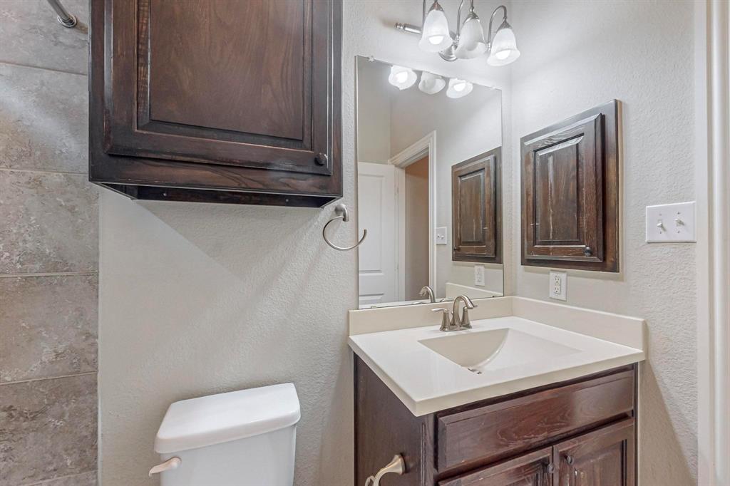 6723 Capistrano Street Irving, TX 75039 - Photo 32 of 40 a bathroom with a sink a toilet and mirror