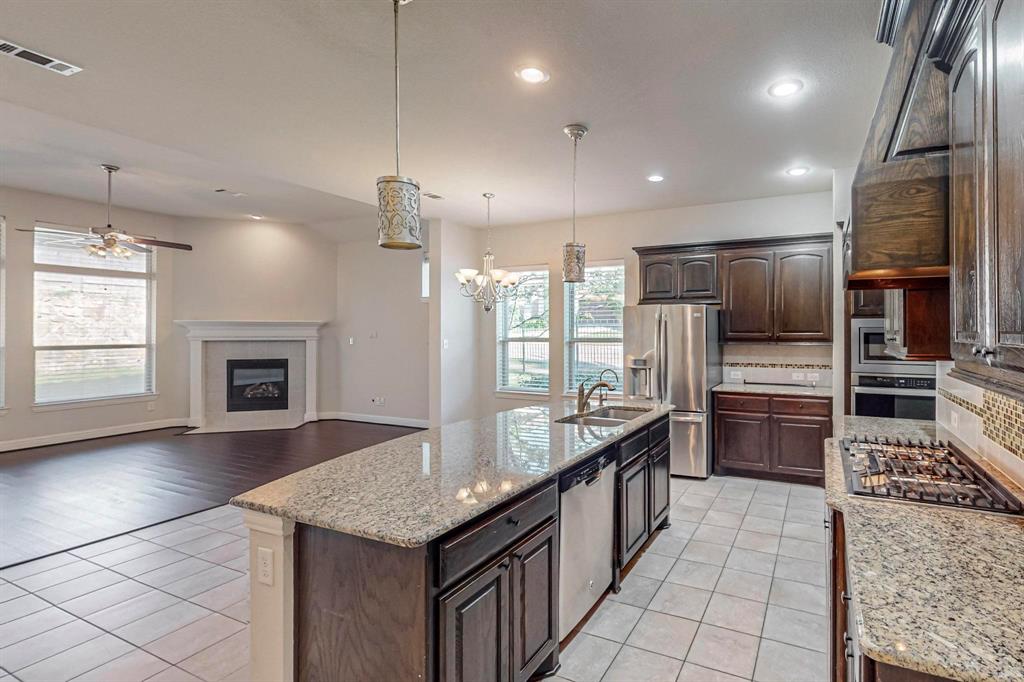6723 Capistrano Street Irving, TX 75039 - Photo 9 of 40 a large kitchen with kitchen island granite countertop a large counter top stainless steel appliances and cabinets