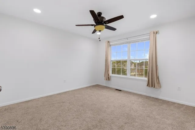 a view of a livingroom with a ceiling fan and window