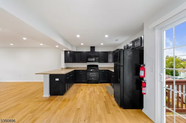 a large kitchen with stainless steel appliances granite countertop a refrigerator and a sink