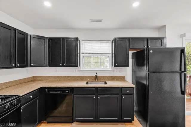 a kitchen with a sink a refrigerator and cabinets