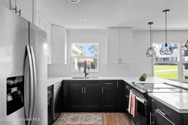 a kitchen with a sink refrigerator and window