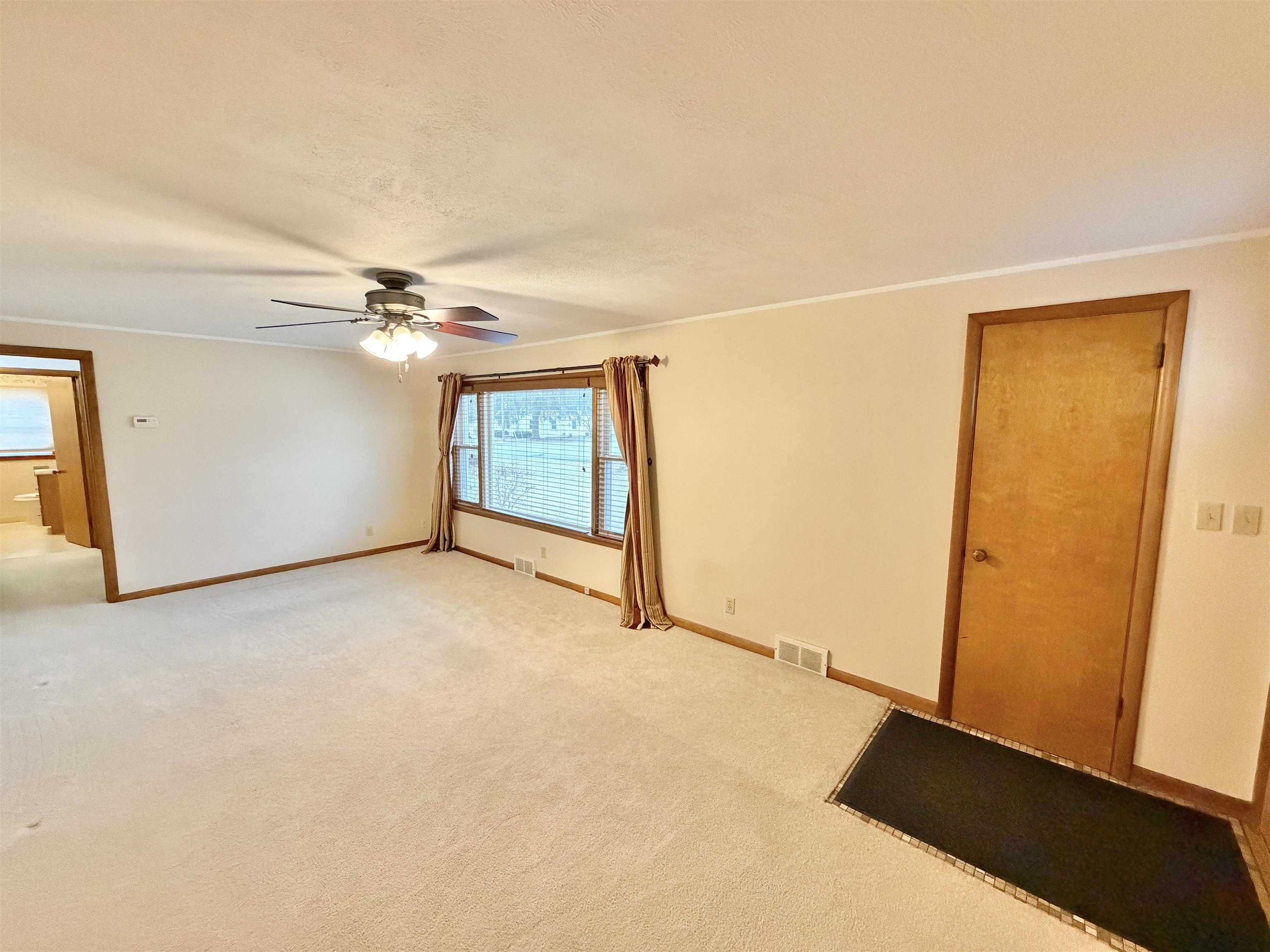 305 West Pershing Street Stillman Valley, IL 61084 - Photo 5 of 37 an empty room with a ceiling fan and a window