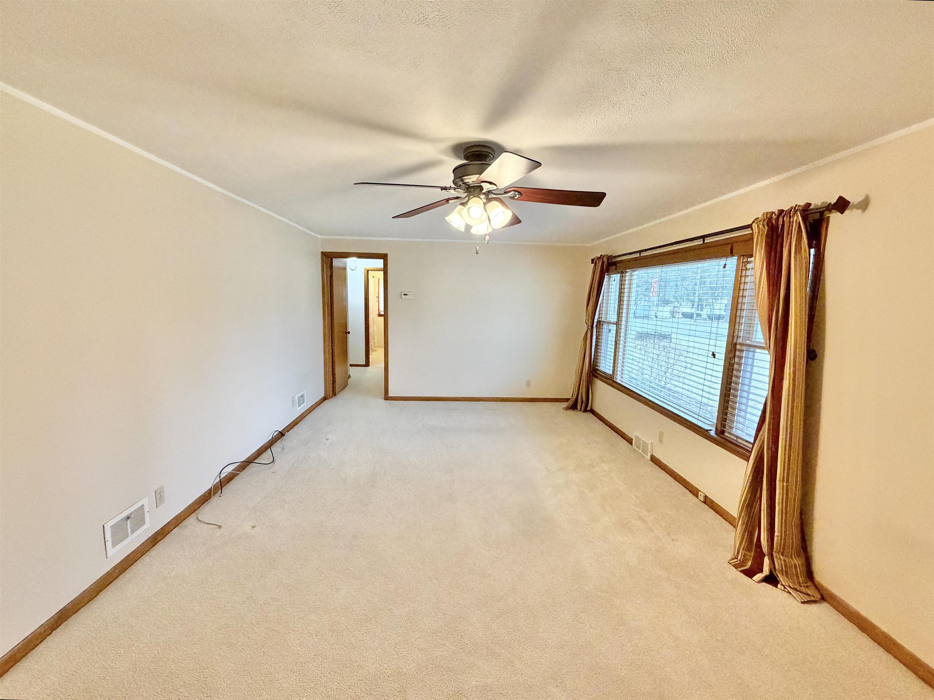 305 West Pershing Street Stillman Valley, IL 61084 - Photo 6 of 37 an empty room with windows and fan
