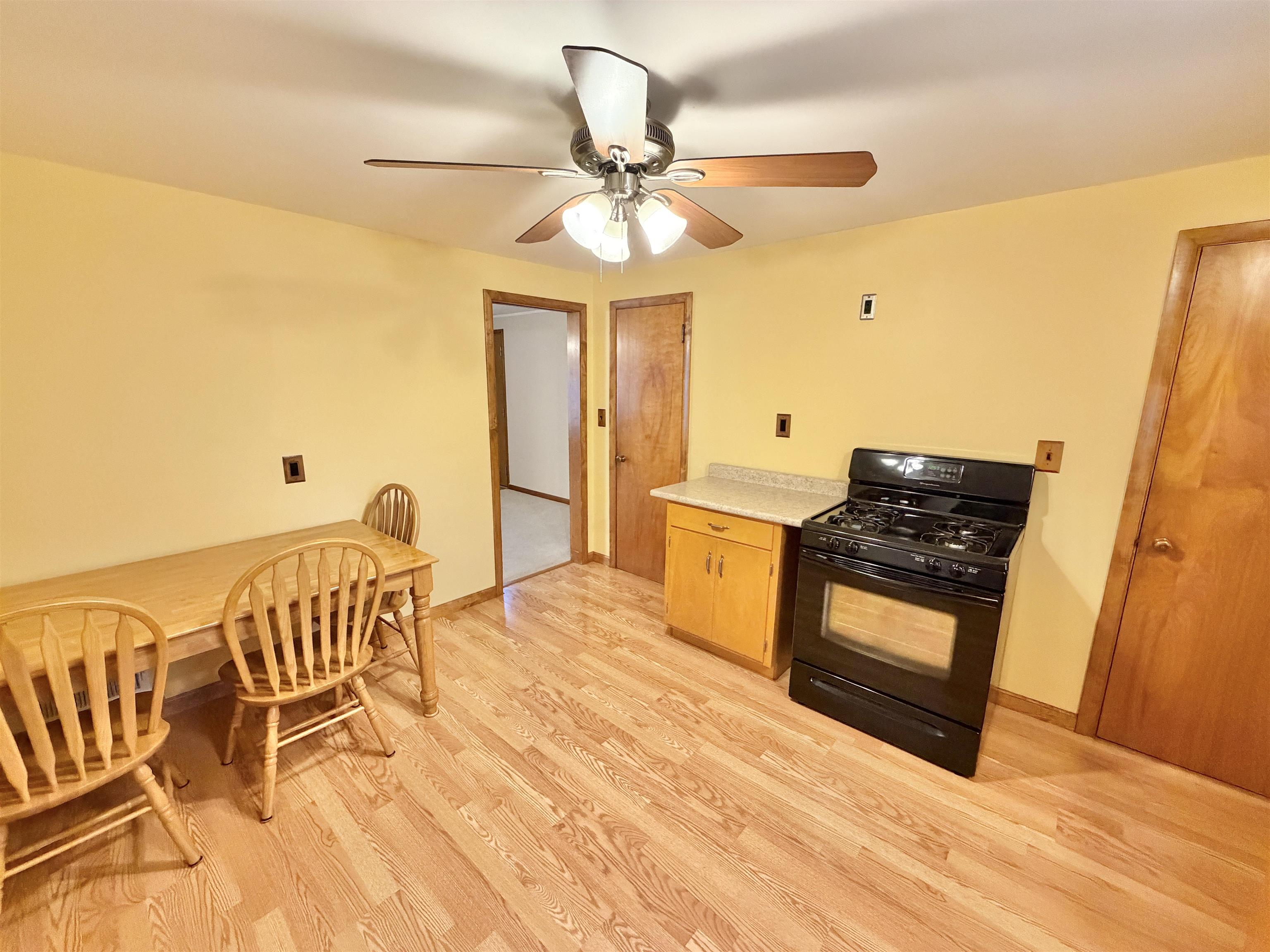 305 West Pershing Street Stillman Valley, IL 61084 - Photo 10 of 37 a living room with a table chairs and a stove