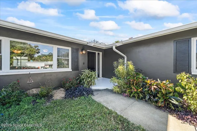 a front view of a house with lots of flowers