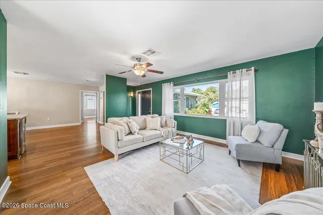 a living room with furniture flowerpot and wooden floor