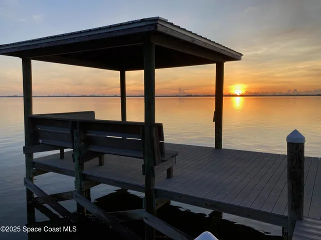 a bedroom with a large bed a flat tv screen and dresser