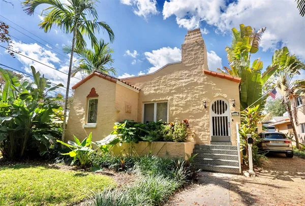 a front view of a house with a yard and a garden