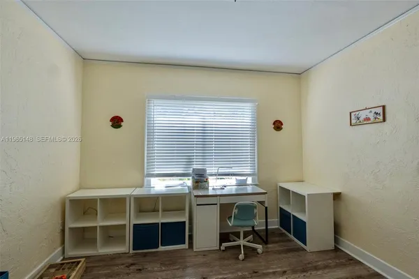 a view of a workspace with furniture and a window