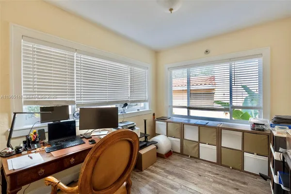 a view of a workspace with furniture and a window