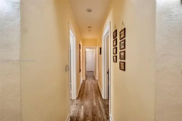 a view of a hallway with wooden floor and staircase