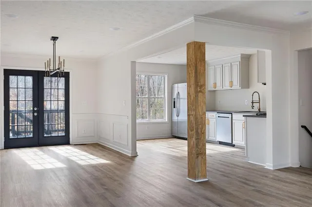 a view of a kitchen with a fridge and wooden floor