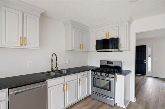 a kitchen with granite countertop a sink and a stove top oven