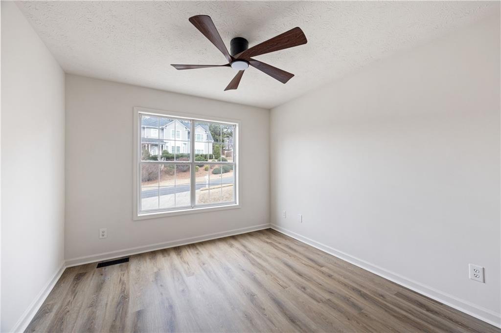 1029 Regency Drive Acworth, GA 30102 - Photo 19 of 36 an empty room with wooden floor ceiling fan and windows