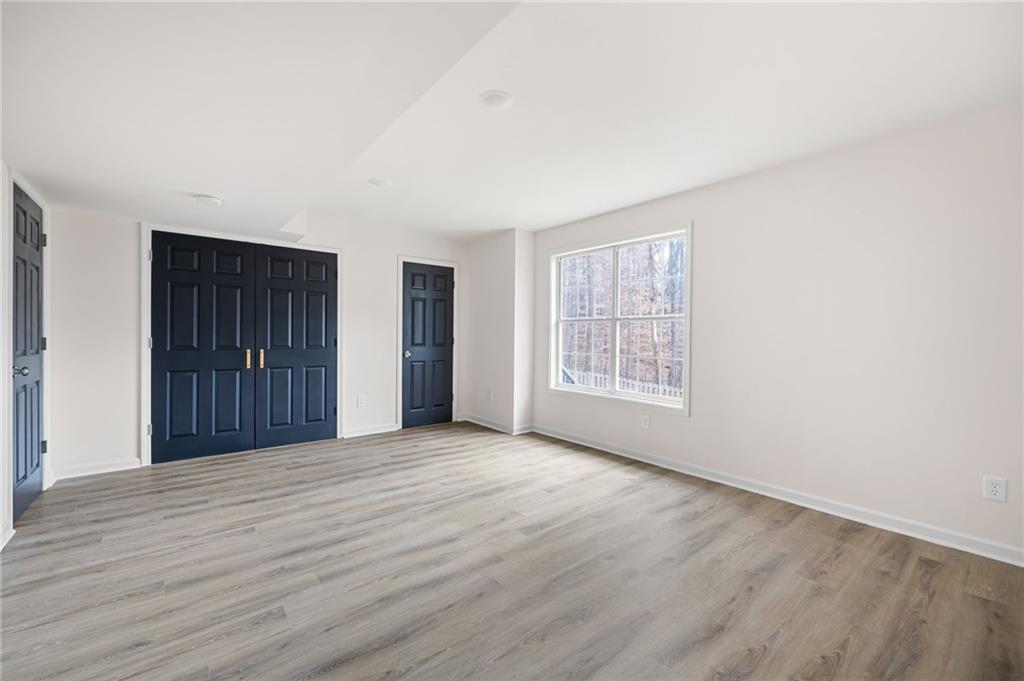 1029 Regency Drive Acworth, GA 30102 - Photo 31 of 36 a view of an empty room with wooden floor and a window