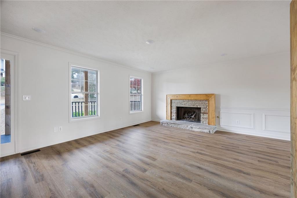 1029 Regency Drive Acworth, GA 30102 - Photo 9 of 36 an empty room with wooden floor fireplace and windows