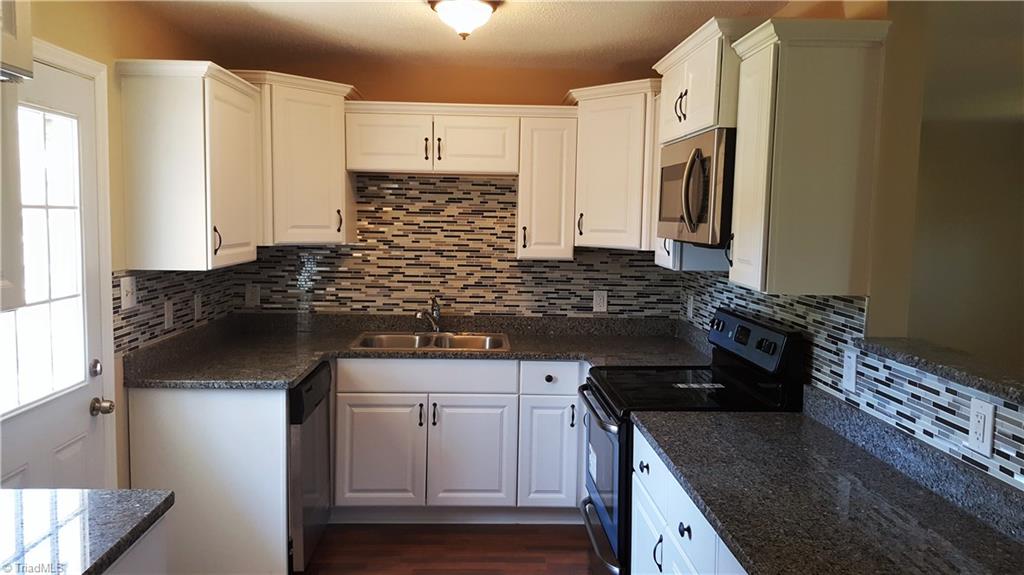8131 East Harrell Road Oak Ridge, NC 27310 - Photo 4 of 13 NEW KITCHEN!! Granite countertops! Tile Backsplash! Stainless appliances! Beautiful cabinetry!
