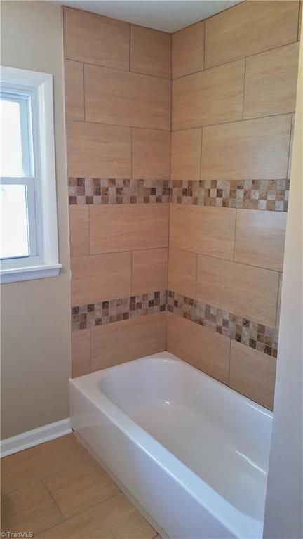 8131 East Harrell Road Oak Ridge, NC 27310 - Photo 10 of 13 Hall bath is ALL NEW!! Windows, tub, fixtures, and beautiful tile surround!!