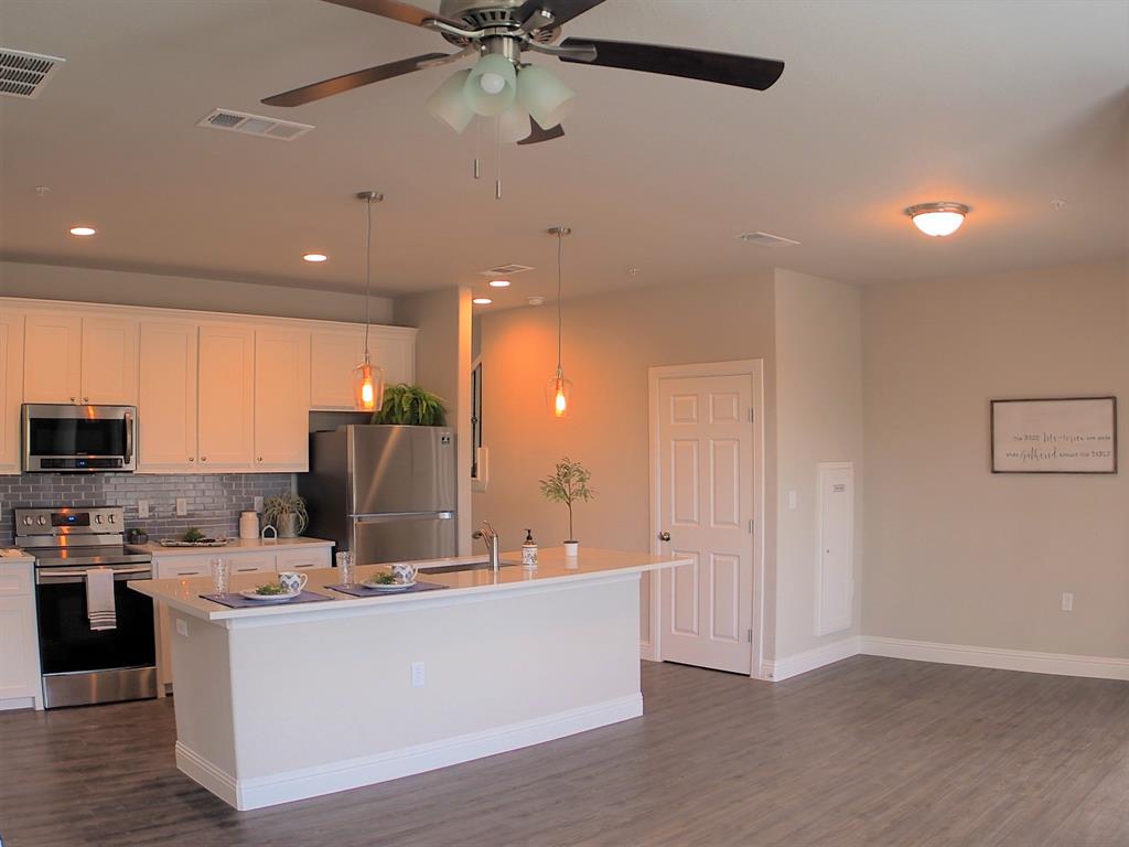 1601 Riney Road Denton, TX 76207 - Photo 4 of 18 a living room with stainless steel appliances kitchen island a flat tv screen and a sink