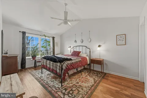 a bedroom with a bed wooden floor and window