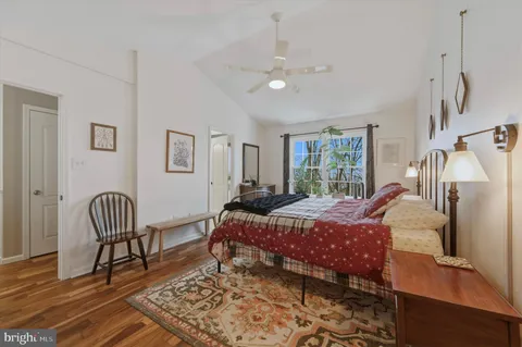 a bedroom with a bed and wooden floor