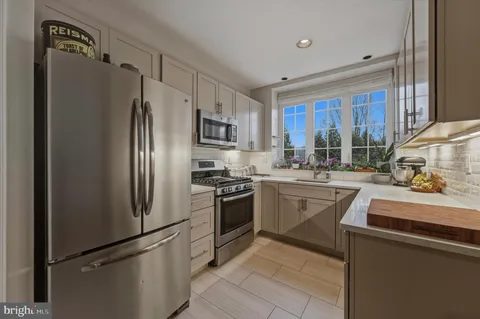 a kitchen with stainless steel appliances granite countertop a refrigerator sink and stove