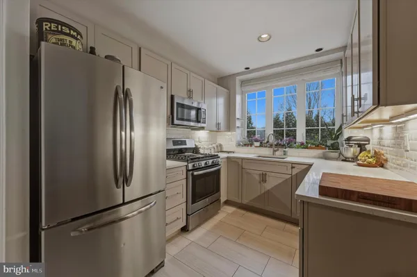 a kitchen with stainless steel appliances granite countertop a refrigerator sink and stove
