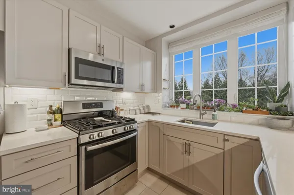 a kitchen with granite countertop a stove sink and cabinets