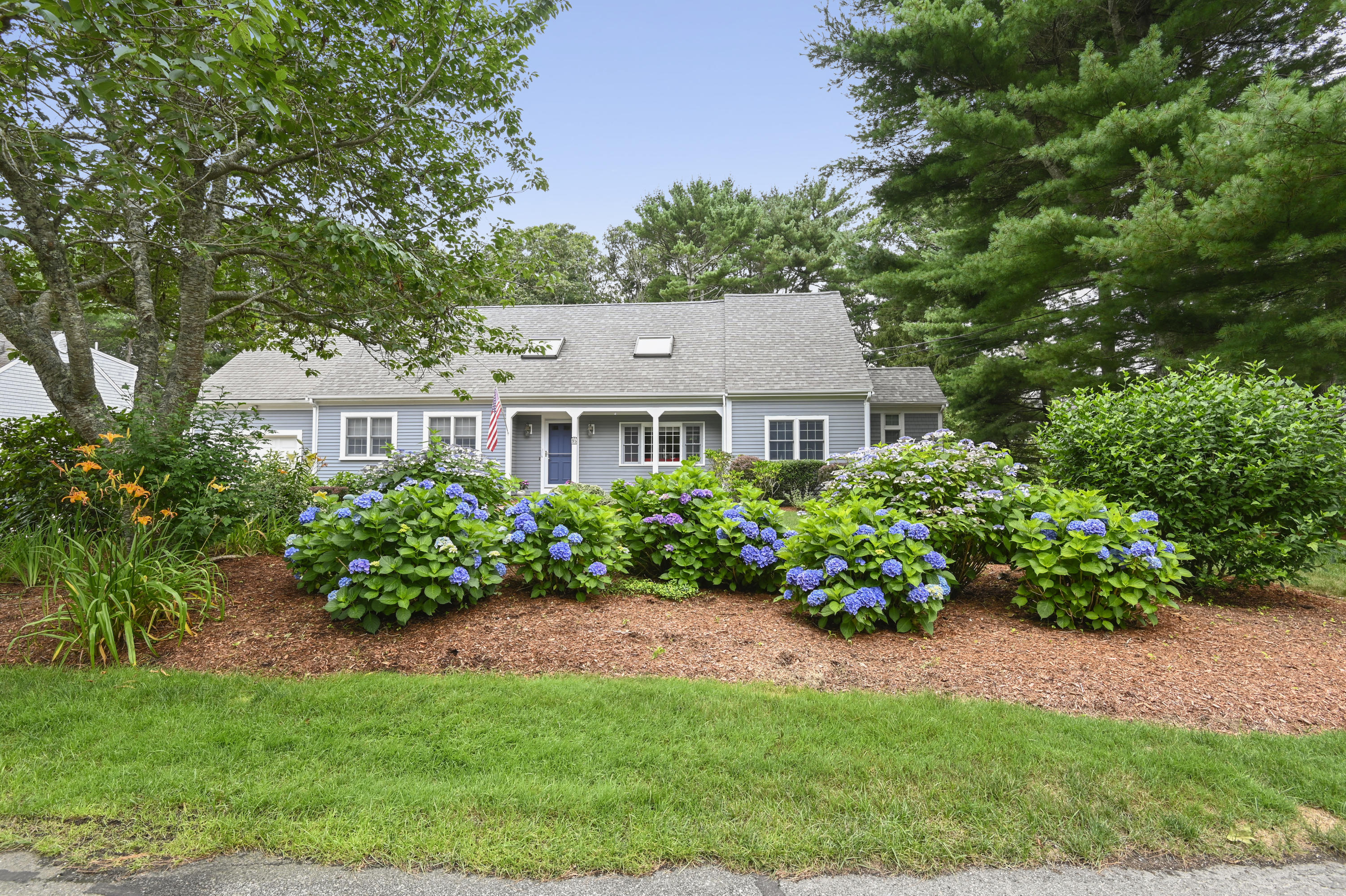 a front view of a house with a yard and flower plants