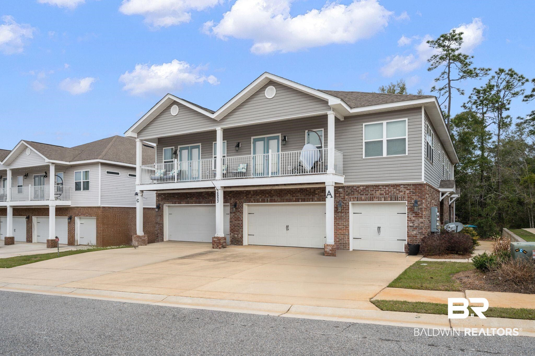 6903 Spaniel Drive, Unit B Spanish Fort, AL 36527 - Photo 1 of 28 View of front facade featuring brick siding, driveway, a balcony, and an attached garage