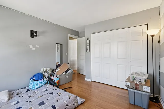 a bedroom with bed and wooden floor