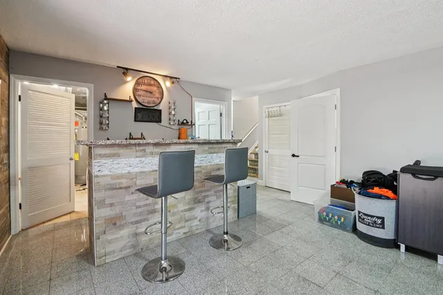 a kitchen with granite countertop cabinets and chair