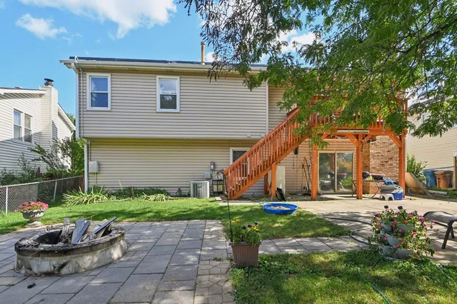 a view of a chair and tables in the back yard of the house