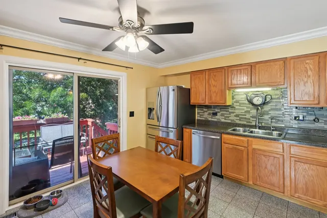 a kitchen with stainless steel appliances granite countertop a stove a refrigerator a sink dishwasher a dining table and chairs with wooden floor