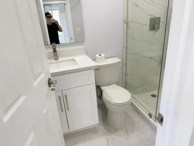 a bathroom with a sink a toilet and shower