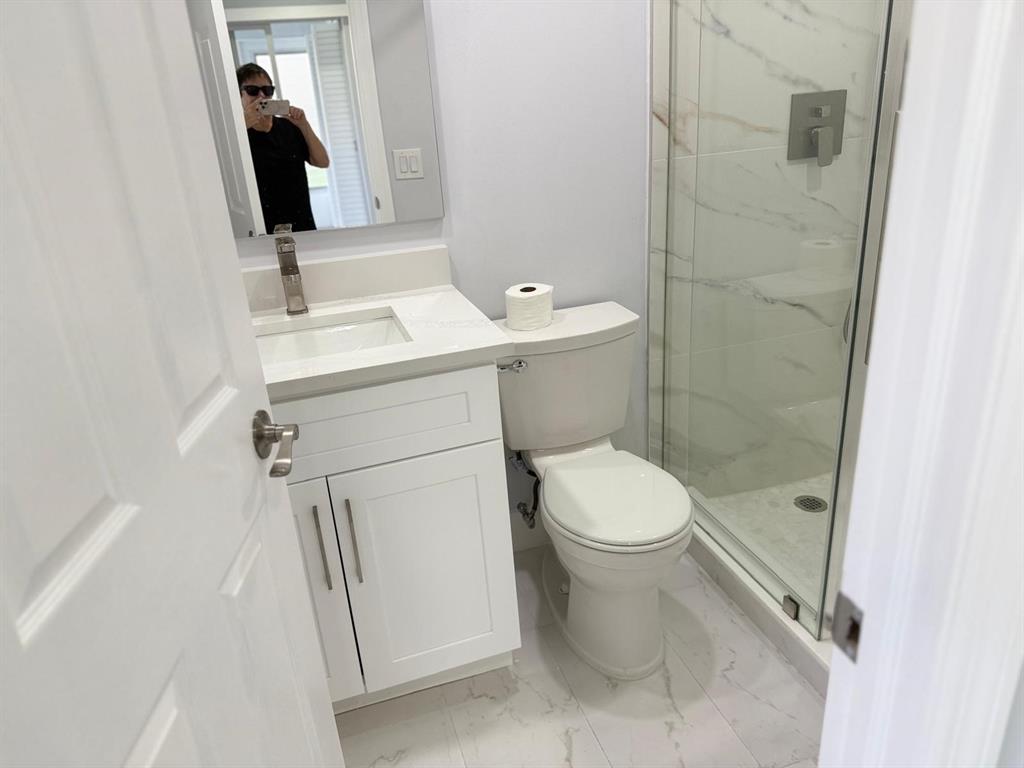 214 Monaco Boulevard, Unit 214 Delray Beach, FL 33446 - Photo 15 of 22 a bathroom with a sink a toilet and shower