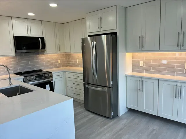 a kitchen with stainless steel appliances a refrigerator stove and microwave