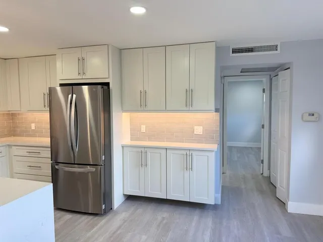 a kitchen with stainless steel appliances granite countertop a refrigerator and a stove top oven