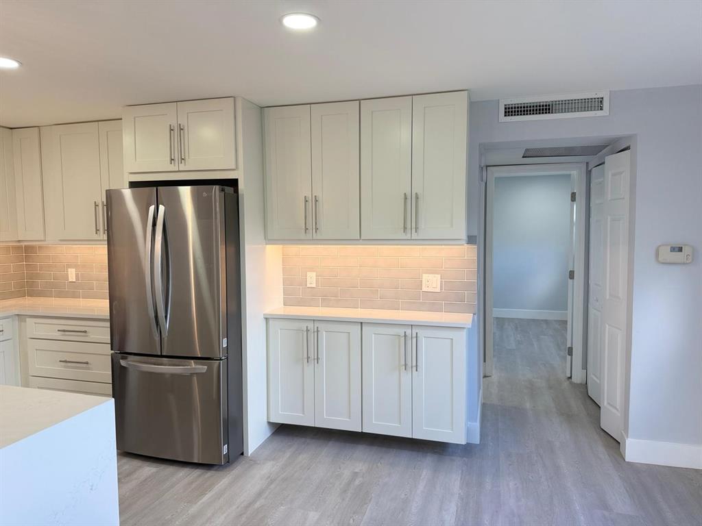 214 Monaco Boulevard, Unit 214 Delray Beach, FL 33446 - Photo 3 of 22 a kitchen with stainless steel appliances granite countertop a refrigerator and a stove top oven