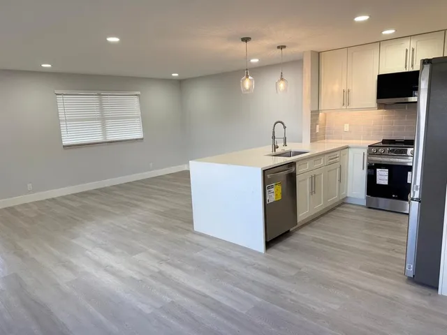 a large kitchen with stainless steel appliances granite countertop a stove and a sink