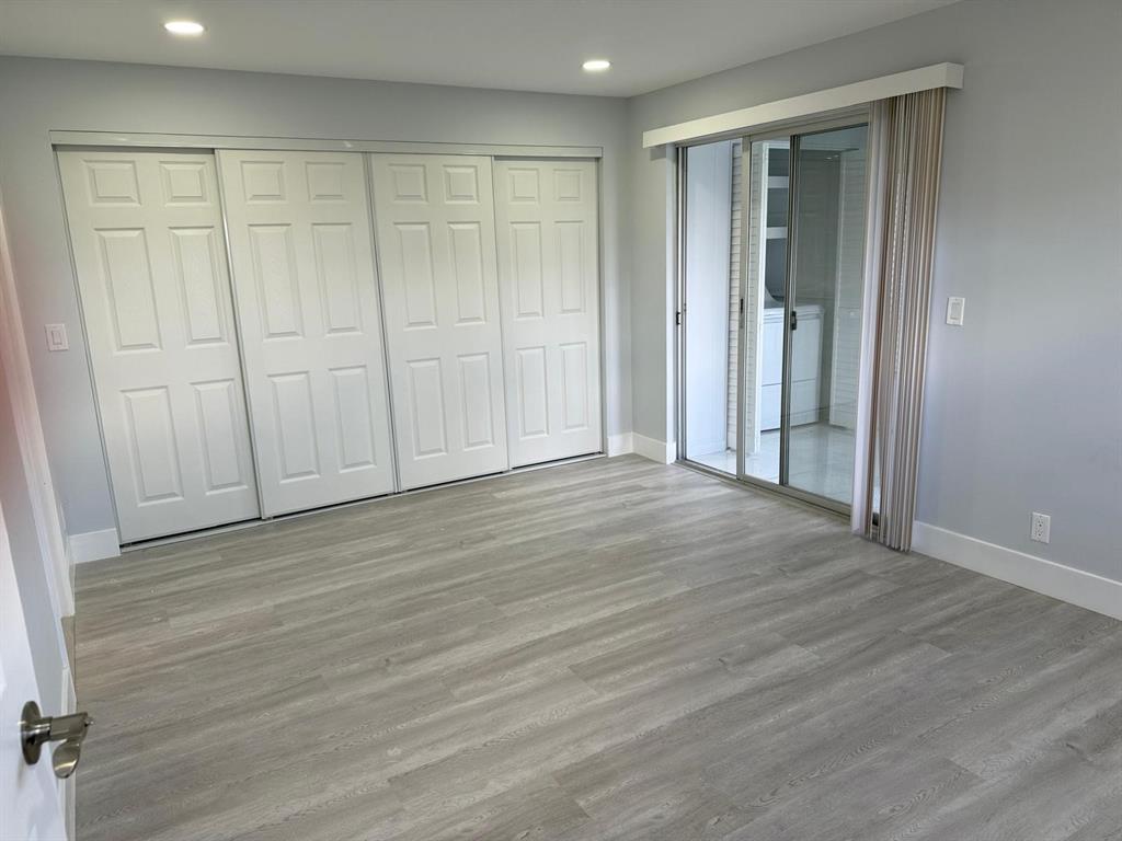 214 Monaco Boulevard, Unit 214 Delray Beach, FL 33446 - Photo 9 of 22 a view of an empty room with wooden floor