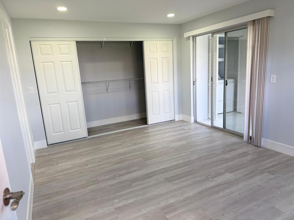 214 Monaco Boulevard, Unit 214 Delray Beach, FL 33446 - Photo 10 of 22 an empty room with wooden floor and closet area