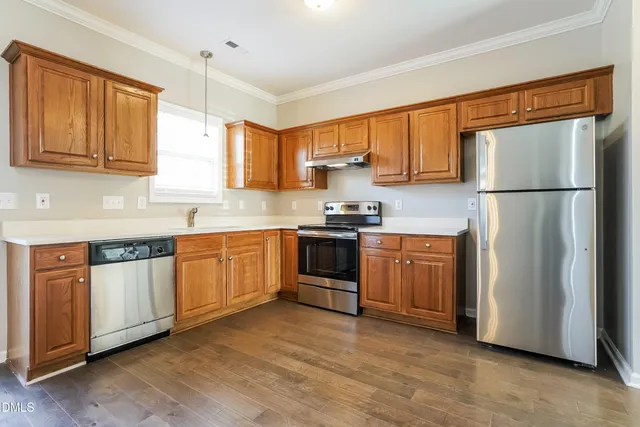a kitchen with stainless steel appliances a refrigerator sink and cabinets