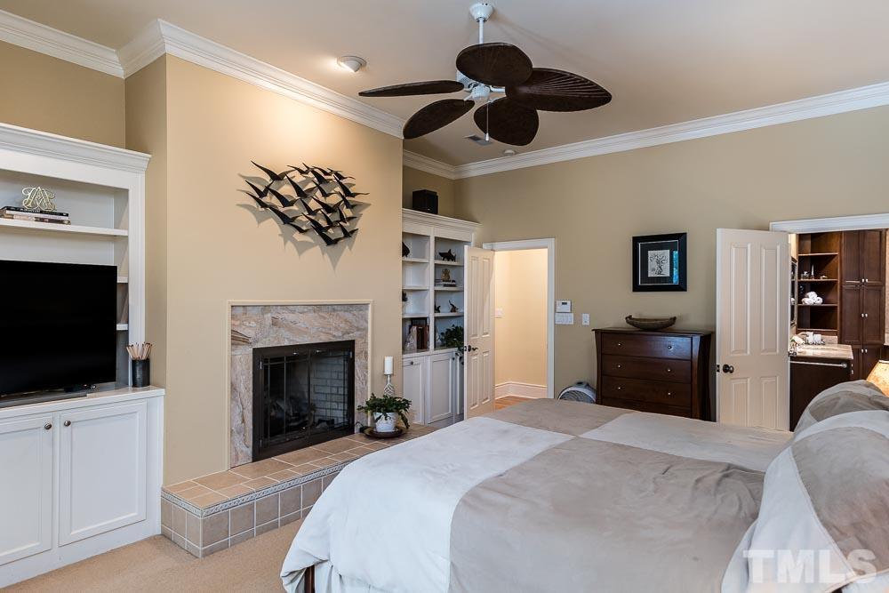 5204 Atherton Bridge Road Raleigh, NC 27613 - Photo 14 of 27 a bedroom with furniture fireplace and flat screen tv