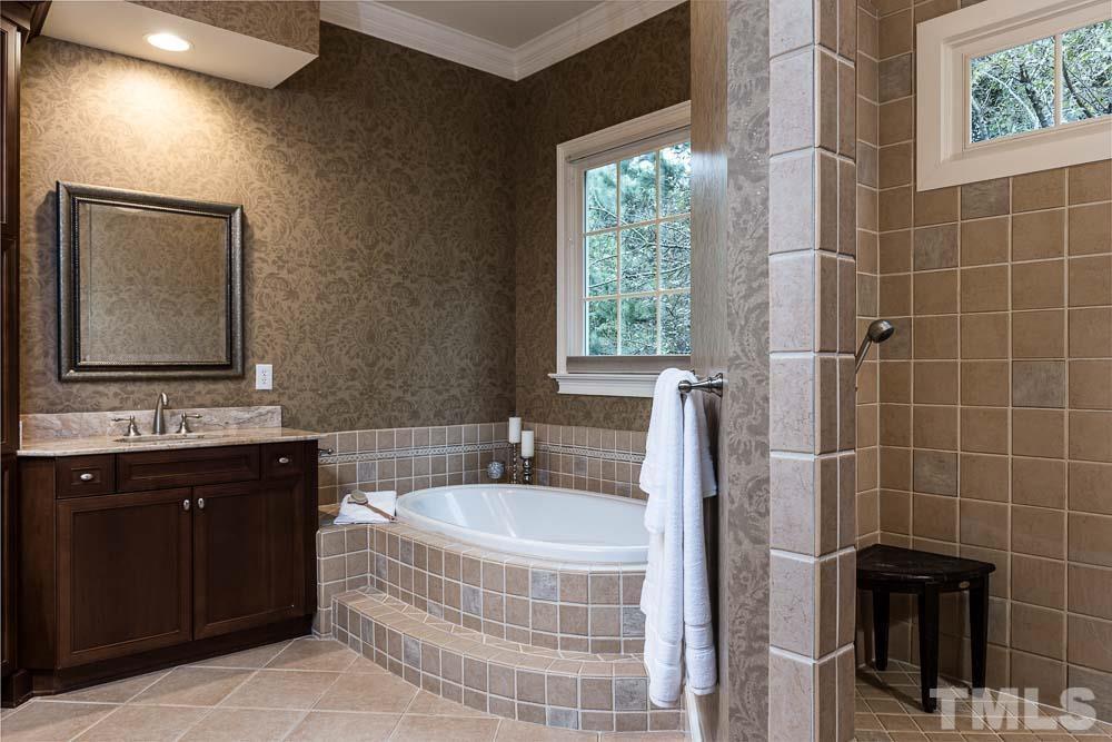 5204 Atherton Bridge Road Raleigh, NC 27613 - Photo 15 of 27 a bathroom with a double vanity sink a mirror and a bathtub