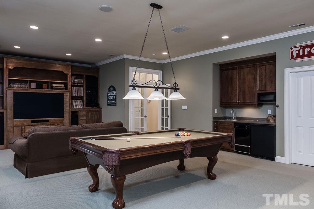 5204 Atherton Bridge Road Raleigh, NC 27613 - Photo 23 of 27 a living room with pool table furniture and a flat screen tv
