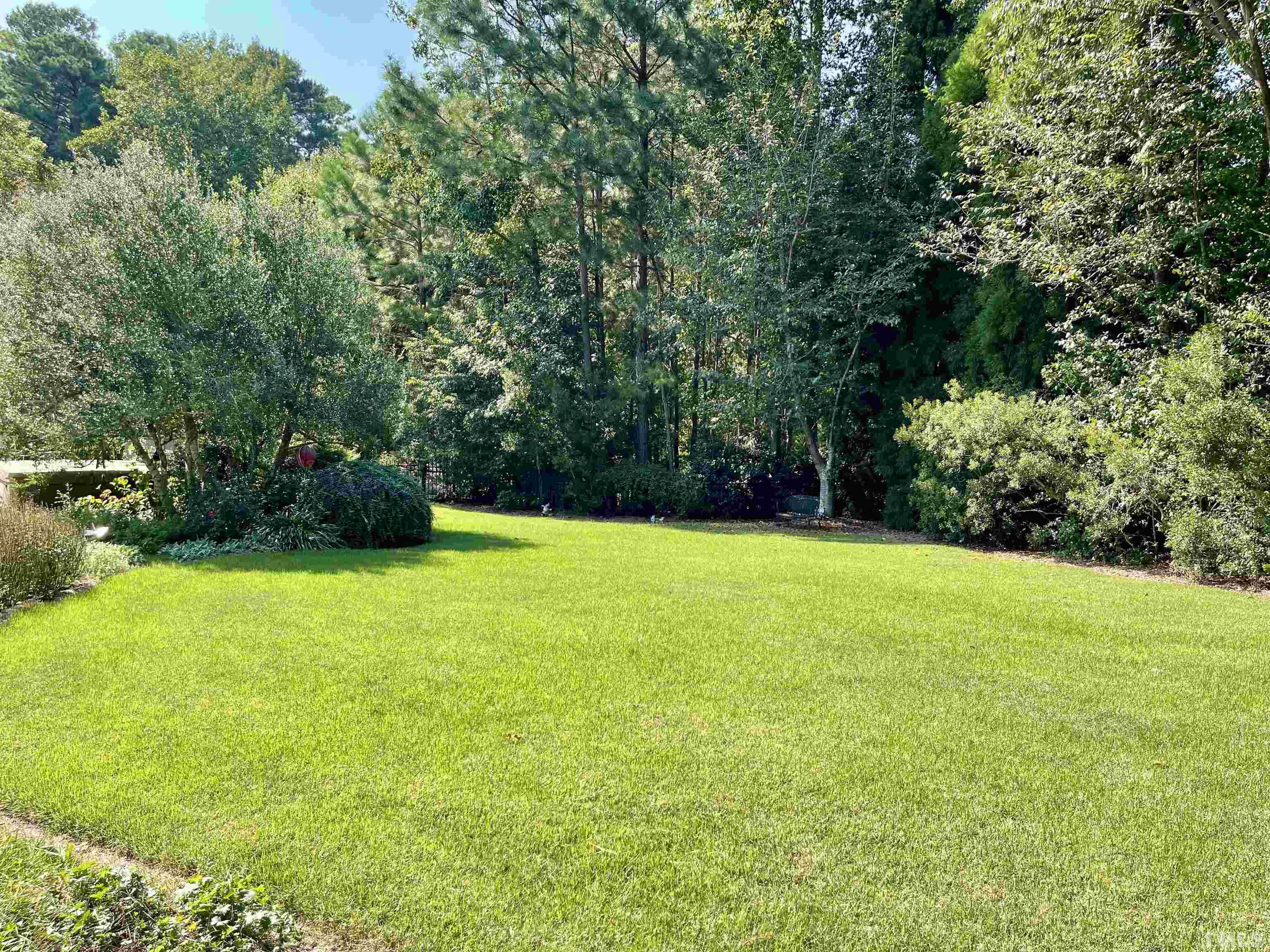 5204 Atherton Bridge Road Raleigh, NC 27613 - Photo 4 of 27 a view of a field of grass and trees