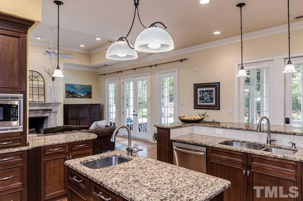 5204 Atherton Bridge Road Raleigh, NC 27613 - Photo 10 of 27 a kitchen with granite countertop a sink a stove and a wooden floors